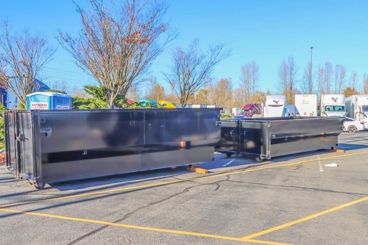 Professional dumpster rental service with roll-off container on residential driveway in Gardere